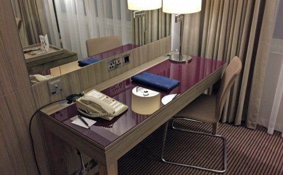 Skrivebord med skandinavisk stikkontakt, tilslutning til TV (HDMI/DVI) og en ældre telefon.